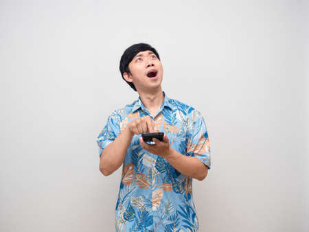 Young man press finger at mobile phone feels excited looking upの写真素材