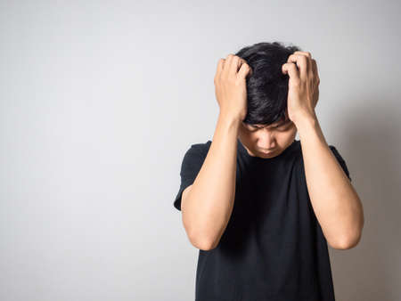 Depressed man hold head feels hopeless white background