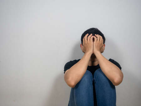 Sad man sit on floor close his face feels hopeless copy spaceの写真素材