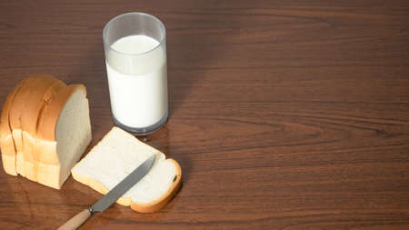 Loaf bread slice with knife with glass of milk on table copy space top viewの写真素材