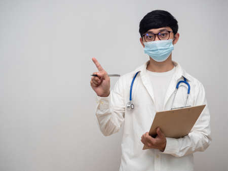 Doctor wearing mask hold check list point finger at copy spaceの写真素材