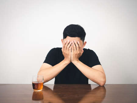 Man alcoholism hangover sitting and close his face feels lonelyの写真素材