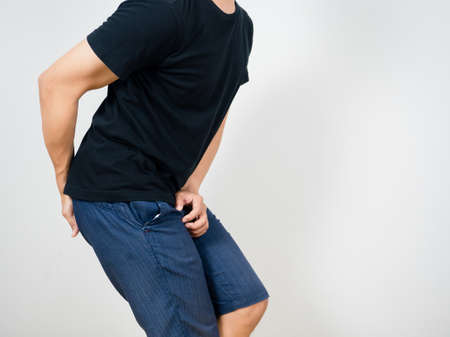 Man gesture pain pee with pain poop isolated studio shotの写真素材