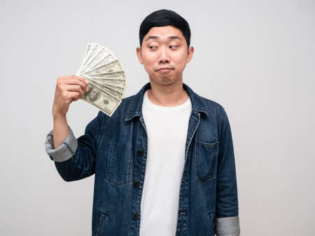 Positive man jeans shirt feels proud with earn money in his hand isolated