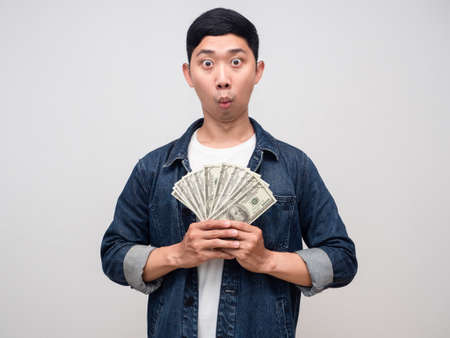 Young man jeans shirt hold a lot of money feels amazed isolatedの写真素材