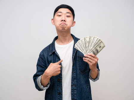 Young man jeabs shirt boast with money in hand point finger at himself isolatedの写真素材