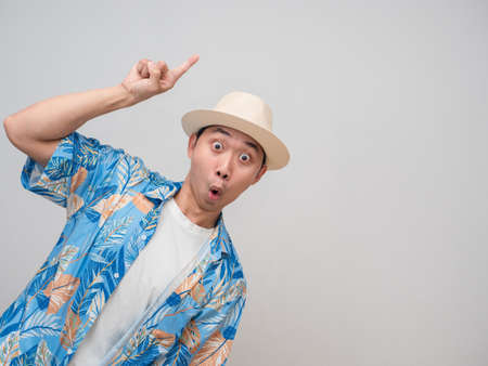 Positive man wear hat beach feels amazed point finger at copy spaceの写真素材