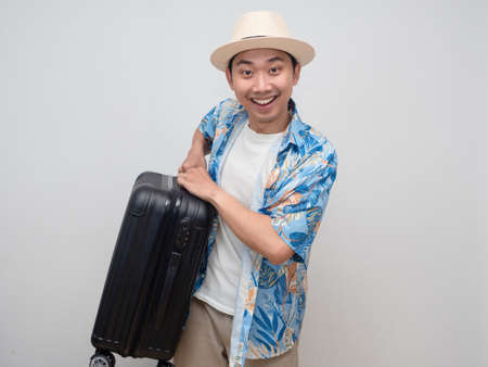 Positive traveler man smile happy and carry luggage isolatedの写真素材