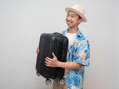 Young traveler man wear hat happy holiday carry luggageの写真素材