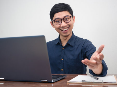 Cheerful businessman sitting at working table looking at youの写真素材