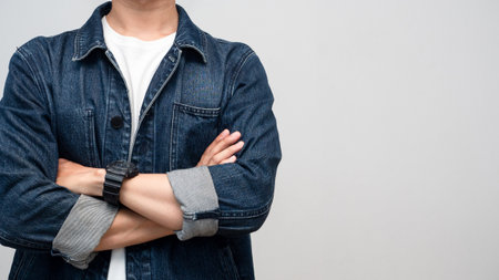 Close up man wear jeans shirt with watch arms crossed studio shot isolatedの写真素材