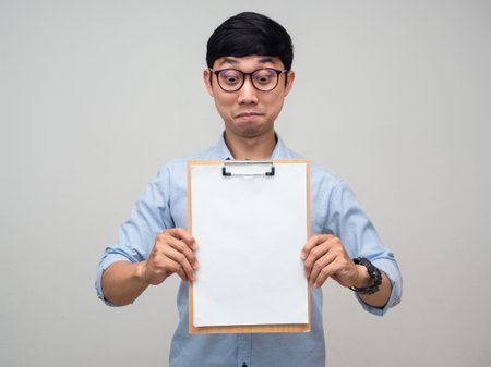 Positive asian man wear glasses smile and showing blank document board in hand isolatedの写真素材