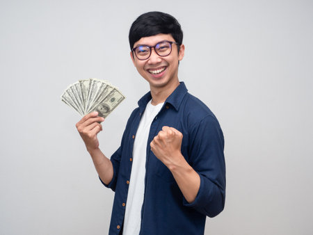 Positive asian man glasses show fist up about earn money success workingの写真素材