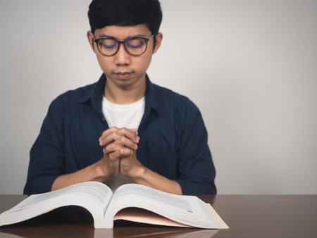 Asian man wear glasses joy hands wish to pass testing at tableの写真素材