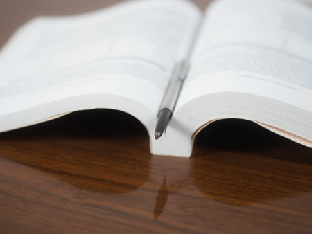 Close up pen and school book open page on the tableの写真素材