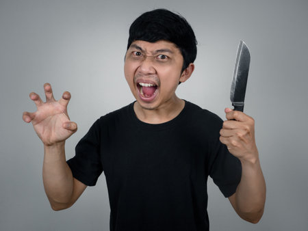 Mad man murder holding knife gesture screming scared at youの写真素材