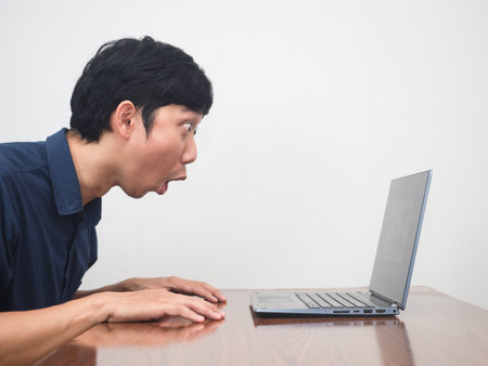 Businessman feels amazed looking at laptop on the tableの写真素材