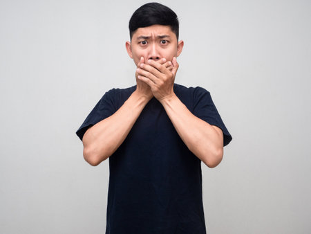 Man black shirt feels shocked close his mouth isolatedの写真素材