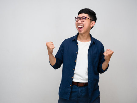 Positive asian businessman happy successful show fist up isolatedの写真素材