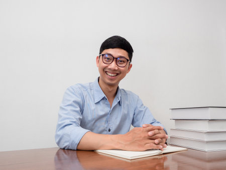 Positive businessman wear glasses sitting at his working table happy smileの写真素材