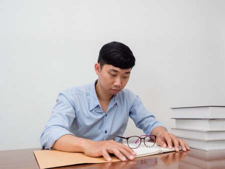 Young businessman sit at table take off his glasses feels tried about working