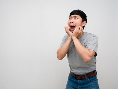Asian man grey shirt standing gesture amazed feels shocked isolatedの写真素材