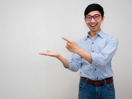 Portrait manager man blue shirt smiling show hand point finger isolatedの写真素材