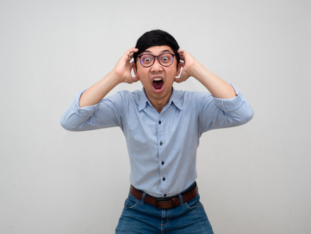 Young businessman wear glasses feels shocked gesture looking isolatedの写真素材