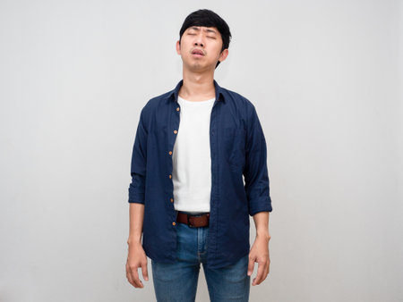 Asian man standing feels tried about hard working isolatedの写真素材