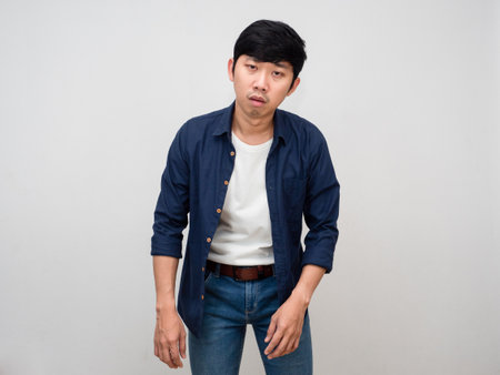 Asian man standing feels tried about hard working isolatedの写真素材