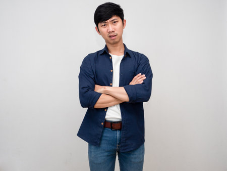 Asian businessman feels serious face standing crossed arms isolatedの写真素材
