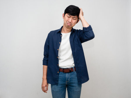 Depressed asian man feels sad gesture hold his head isolatedの写真素材