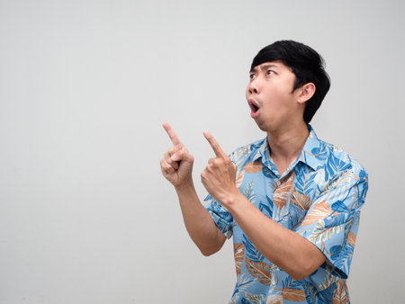 Asian tourism man blue shirt feels excited gesture point finger at copy spaceの写真素材