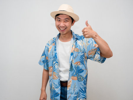 Cheerful tourism asian man happy smile show thumb up isolatedの写真素材