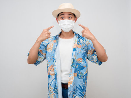 Tourism asian man beach shirt point finger at face mask isolatedの写真素材
