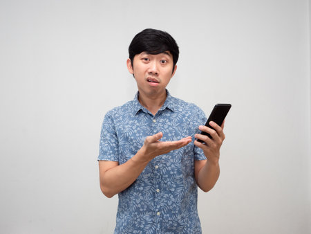 Confused asian man holding smartphone isolatedの写真素材