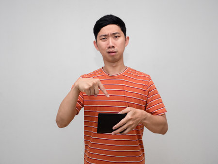 Asian man orange striped feels sad with no money in wallet isolated,Poor man unhappy about not enought moneyの写真素材