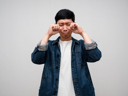 Sadness asian man jeans shirt feels disheartened,cry,headache isolatedの写真素材
