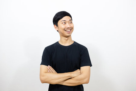 Positive asian man black shirt smile and cross arm gesture looking isolatedの写真素材