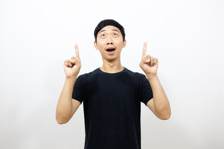 Positive asian man black shirt smile and gesture point finger up isolatedの写真素材