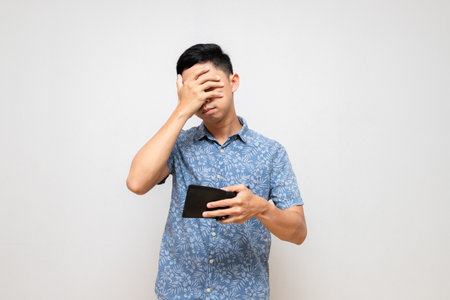 Poor man blue shirt holding wallet feels unhappy and sad isolatedの写真素材