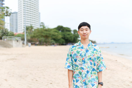 Portrait asian man tourism  happy smiling on the beach with beautiful ocean background copy spaceの写真素材