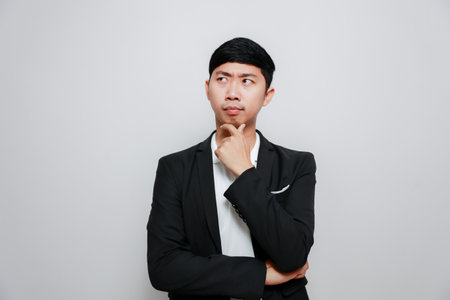 Asian man black suit gesture cross arm thinking and thoughtful isolatedの写真素材