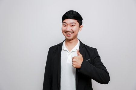 Cheerful business man black suit show thumb up confident happy smileの写真素材