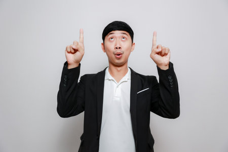 Cheerful business man gesture point finger up isolatedの写真素材
