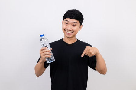 Positive asian man black shirt gesture open water bottle with happy smile point finger down isolatedの写真素材