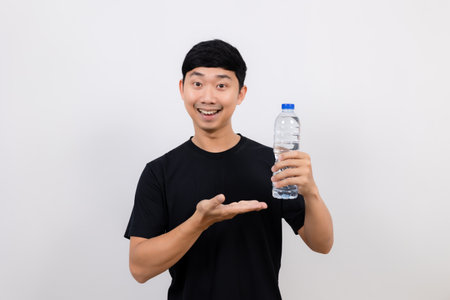Positive asian man black shirt show water plastic bottle isolatedの写真素材