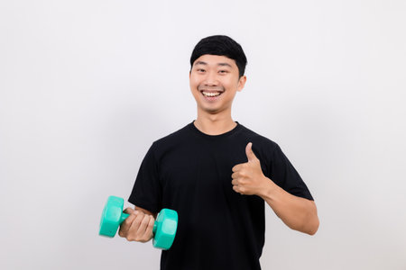 positive asian man black shirt work out with dumbbell show thumb up isolatedの写真素材