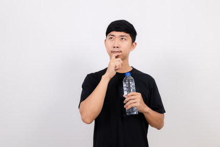 Positive asian man black shirt hold water bottle gesture thinking isolatedの写真素材
