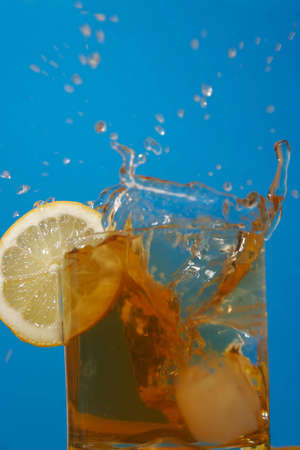 Ice floe falling into whisky glass causing from the splashesの写真素材